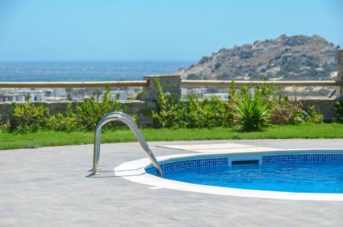 a swimming pool with a faucet in a yard at Naxos Luxury Villas in Mikri Vigla
