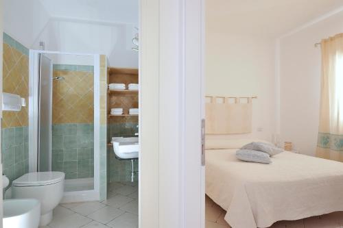 a bathroom with a bed and a toilet and a sink at La casa di Leo in Santa Maria Navarrese