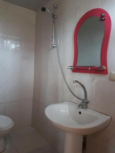 a bathroom with a sink and a mirror on the wall at Talo's Guest House in Makhinjauri