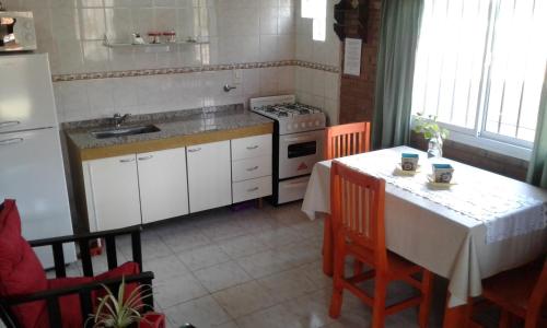 a kitchen with a table and a sink and a stove at Cabañas Llajta Sumaj in Las Calles