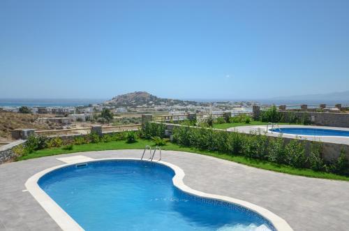 a swimming pool with a view of the ocean at Naxos Luxury Villas in Mikri Vigla