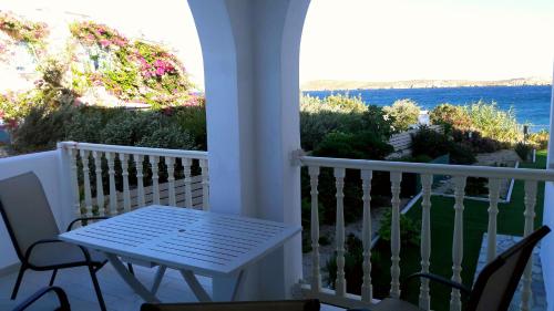 a white porch with a table and chairs and the ocean at Kleanthi Apartments in Drios