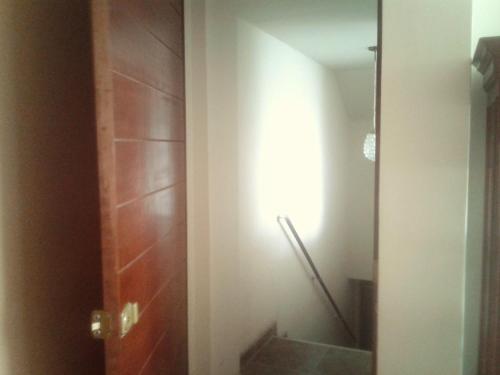 a bathroom with a toilet and a light on the wall at La Casa del Che Fernando in Lima