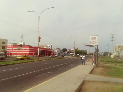 a man standing on a sidewalk next to a street at La Casa del Che Fernando in Lima