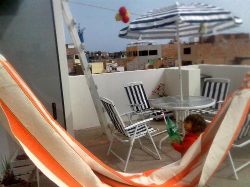 a little boy sitting in a hammock on a balcony at La Casa del Che Fernando in Lima