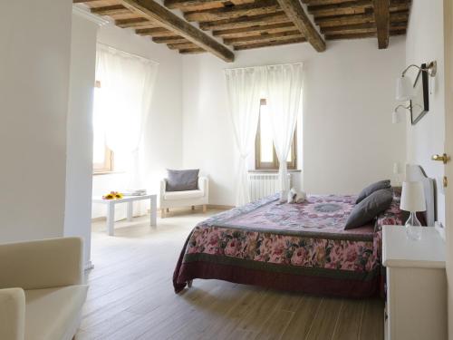 1 dormitorio blanco con 1 cama y 1 silla en Monnalisa, en Castiglione di Garfagnana