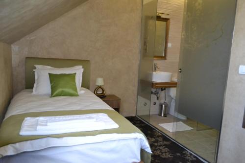 a bedroom with a bed and a bathroom with a sink at Garni Hotel Chicha - Winery &Scaron;KRBIĆ in Belgrade