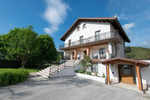 a white house with stairs and a balcony at Albergo Della Corte in Pescasseroli