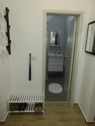 a bathroom with a toilet and a sink with a mirror at Summer apartment in Bar