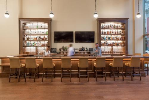 a bar in a restaurant with people standing behind it at NOPSI Hotel New Orleans in New Orleans