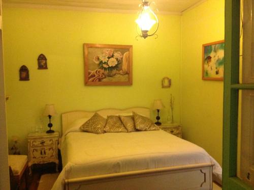 a bedroom with a bed with yellow walls at Hostal Renoir in San Fernando