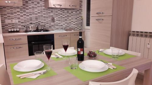 a dining table with a bottle of wine and glasses at Bolognamania Apartments-Prime in Bologna