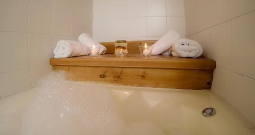 a bath tub with candles and towels in a bathroom at Hostería El Arbol Duende in San Martín de los Andes