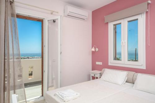a bedroom with a bed and a large window at Naxos Luxury Villas in Mikri Vigla