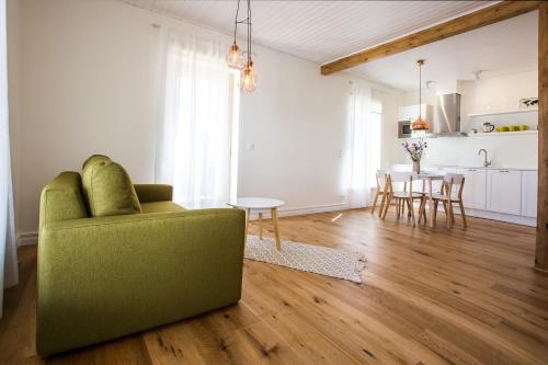 a living room with a green couch and a kitchen at Haapsalu Old Town Apartments in Haapsalu