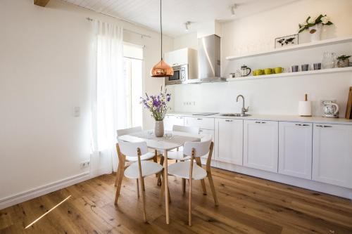 a kitchen with white cabinets and a table and chairs at Haapsalu Old Town Apartments in Haapsalu