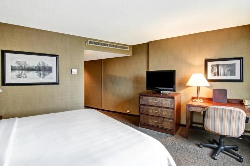 a hotel room with a bed and a desk with a television at Chateau Lacombe Hotel in Edmonton