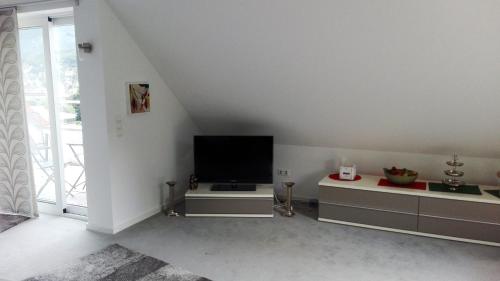 a living room with a flat screen tv in the corner at Ferienwohnung Anita in Annweiler am Trifels
