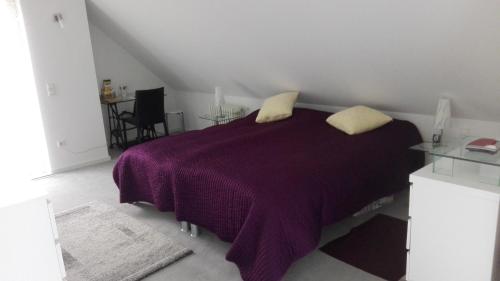 アンヴァイラー・アム・トリフェルスにあるFerienwohnung Anitaのベッドルーム(紫色のベッド1台、枕2つ付)