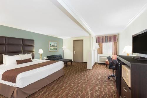 a hotel room with a bed and a flat screen tv at Baymont by Wyndham Helen in Helen