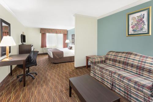 a hotel room with a couch and a bed at Baymont by Wyndham Helen in Helen