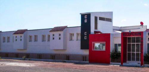 un edificio con una puerta roja a un lado. en Hotel El Pacifico, en Morelia