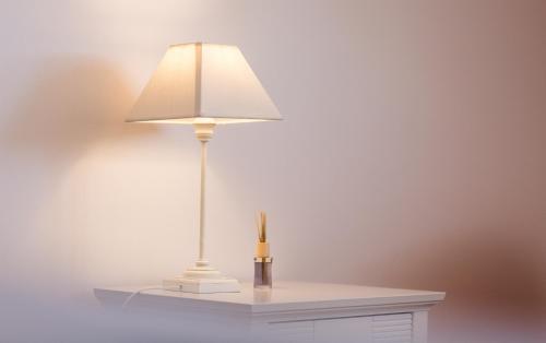 a lamp on a table with a vase on it at Haapsalu Old Town Apartments in Haapsalu