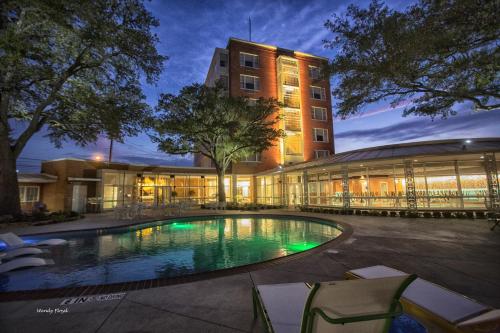 a building with a swimming pool in front of a building at The Fredonia Hotel in Nacogdoches