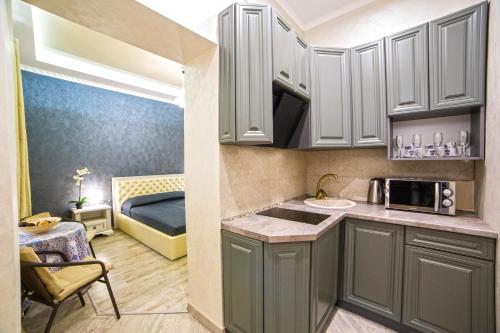 リヴィウにあるRubna 5の白いキャビネット付きのキッチン、ベッド1台が備わる客室です。