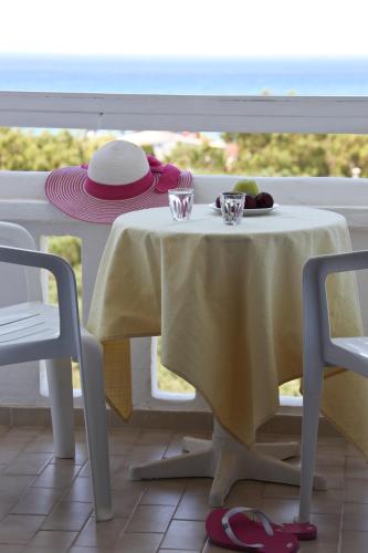 a table with a yellow table cloth and two cups on it at Lofos Hotel in Plakias