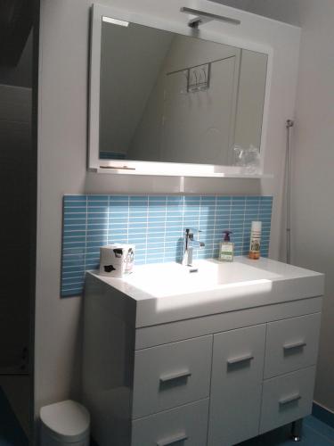 une salle de bain avec un lavabo blanc et un miroir dans l'établissement La Récré, à Restigné