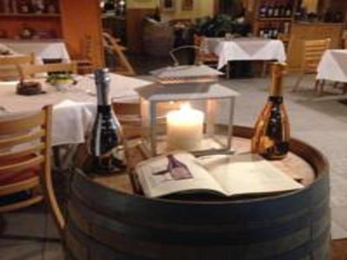 a table with two bottles of wine and a candle at Hotel Concordia in Porlezza