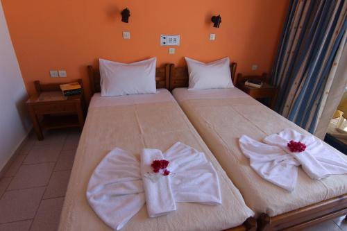 a bedroom with two beds with towels on them at Lofos Hotel in Plakias