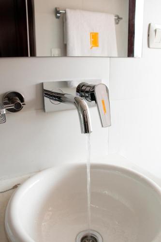 a sink with water coming out of a faucet at Qhini Hotel Boutique in La Paz
