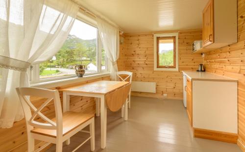 uma pequena cozinha com uma mesa e uma janela em Kabelvåg Feriehus & Camping em Kabelvåg