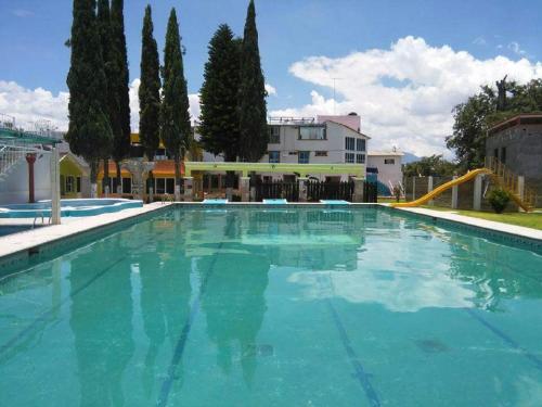 a large swimming pool with blue water at Hotel Cipreses in Ixmiquilpan