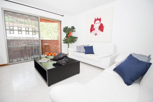 sala de estar con sofá blanco y mesa en San Fernando Suite 201 - Livin Colombia, en Cali