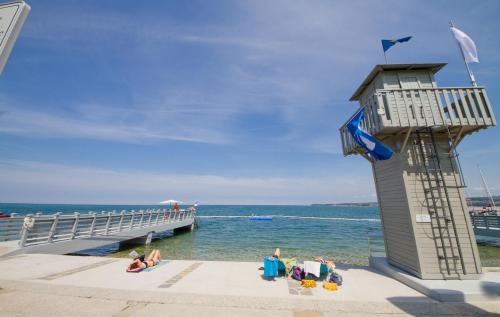 people sitting on the beach near a pier at Sobe pri Anici in Koper