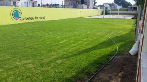 a lawn with a hose on the side of a building at Hotel Cipreses in Ixmiquilpan