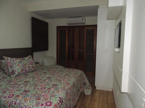 a hotel room with a bed and a dresser and a bedroom at Casa Praia Mole in Florianópolis