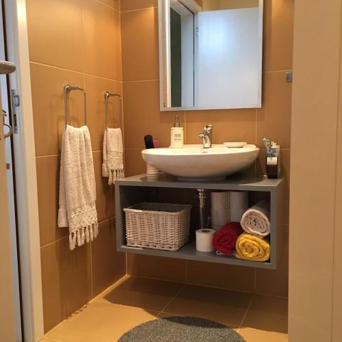 a bathroom with a sink and a mirror and towels at Villa Atlantis in Calheta