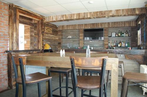 a bar in a restaurant with wooden walls and chairs at Edge of the Avalon Inn in Trepassey
