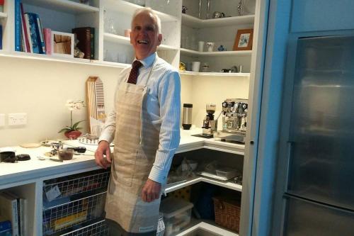 a man wearing an apron standing in a kitchen at Restview in Dunedin