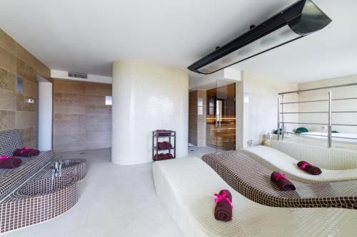 a living room with two couches and a tub at Hotel Sanvit Lake Resort & Spa in Okuninka