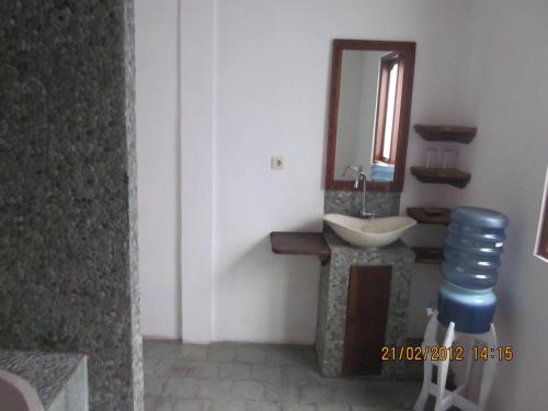 a bathroom with a sink and a mirror at Puri Oka Beach Bungalows in Candidasa