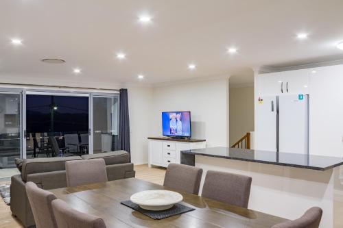 a kitchen and dining room with a table and chairs at Brand New Executive Living 36 in Bundamba