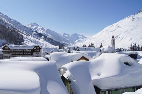 a village covered in snow with mountains in the background at Alpenhotel Schlüssel in Andermatt