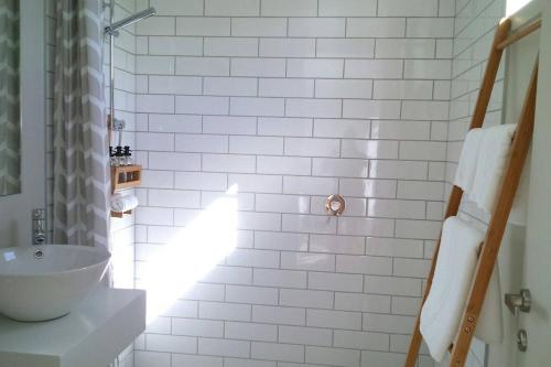 a white bathroom with a sink and a shower at Restview in Dunedin