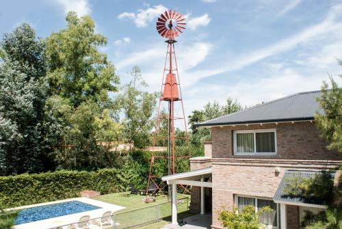 a house with a windmill and a pool at Descanso del Molino in Luján