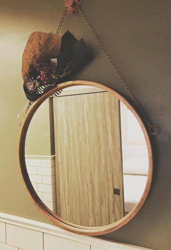 a round mirror with a wooden door in a bathroom at Urban in Kaohsiung